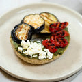 halber Bagel mit gegrillter Paprika, Aubergine , Feta und Basilikumpesto.