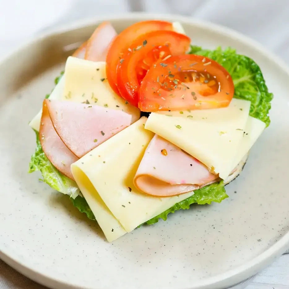 halber Bagel mit  Putenbrust, Käse, Majo, Gurke und Salat.