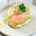 halber Bagel mit Frischkäse, Lachs, Avocado und Sprossen.
