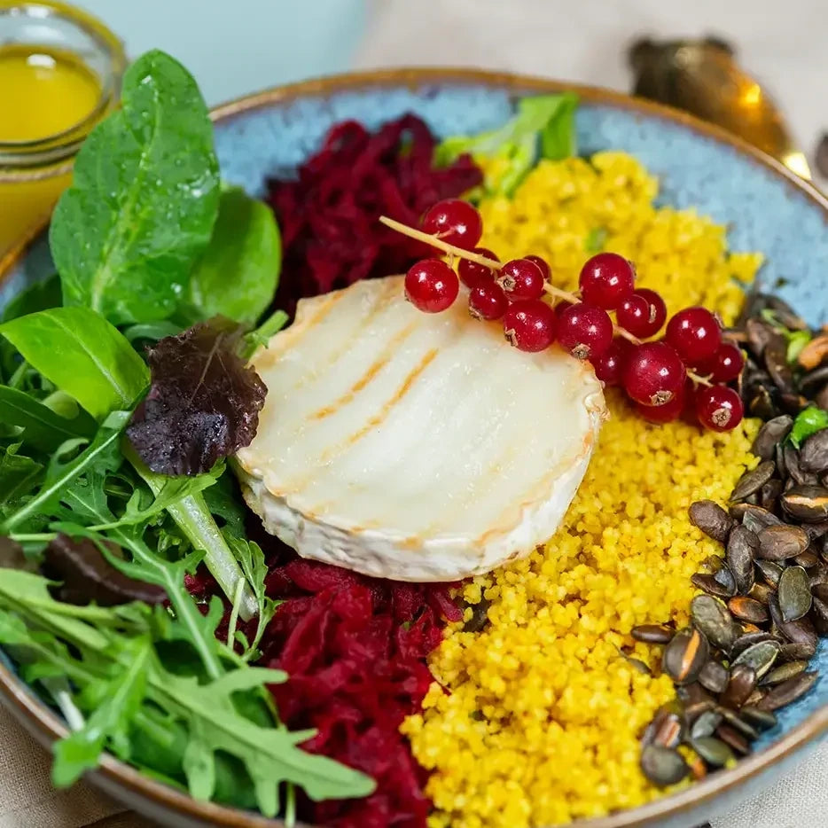 Bowle mit Blattsalat, Couscous, Rote Beete, gegrilltem Ziegenkäse, gerösteten Kürbiskernen und Maracuja-Dressing.