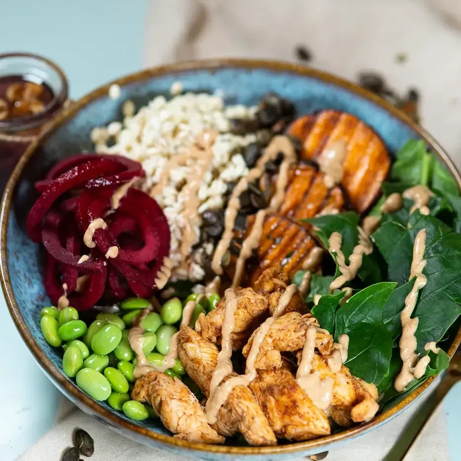 Bowle mit Gerste, Kichererbsen, Edamame, Süsskartoffeln, Spinat, RooteBeete, gerösteten Kürbiskernen, Hähnchen und Erdnusssauce.