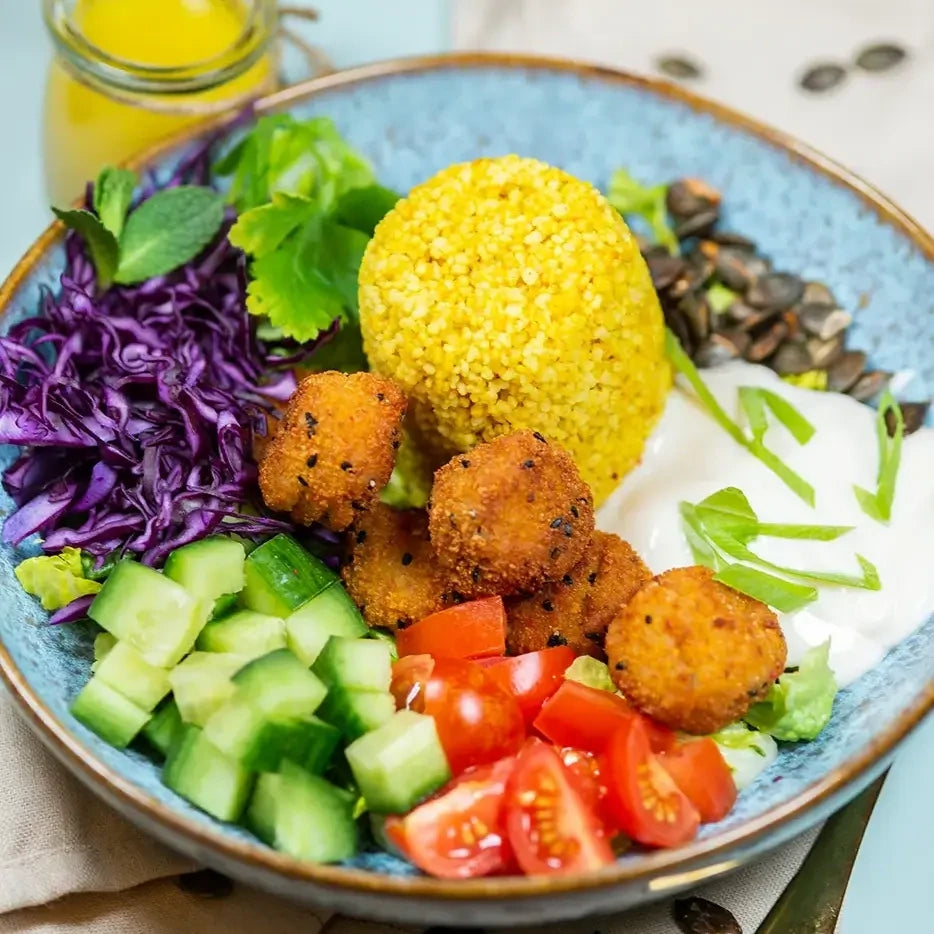 Bowle mit Curry Couscous mit Rotkohl, Tomate-Gurke, geröstetem Kürbiskernen , Falafel und veganer Sour Cream.