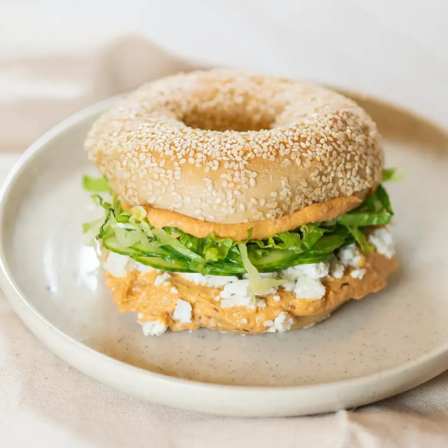 ganzer Bagels mit hausgemachtem leichtem Hummus, Feta, Gurke und Salat.
