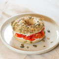 ganzer Bagel mit Frischkäse und Tomate.