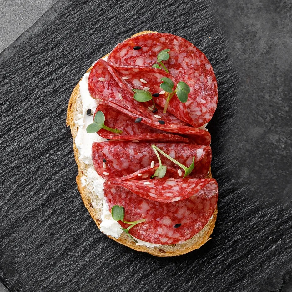 Bruschetta mit Salami, Basilikumpesto, Ruccola und getrockneten Tomaten. 20 Stück