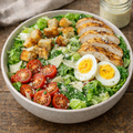 Bowle Cesar Salat mit Hähnchen, Tomaten, Croutons, hartgekochtes Ei und Parmesan