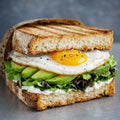 Sandwich mit Frischkäse, Avocado, Salat und Bio Spiegelei.