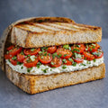 Sandwich  mit Frischkäse, Cherry-Tomaten und Kräutern.